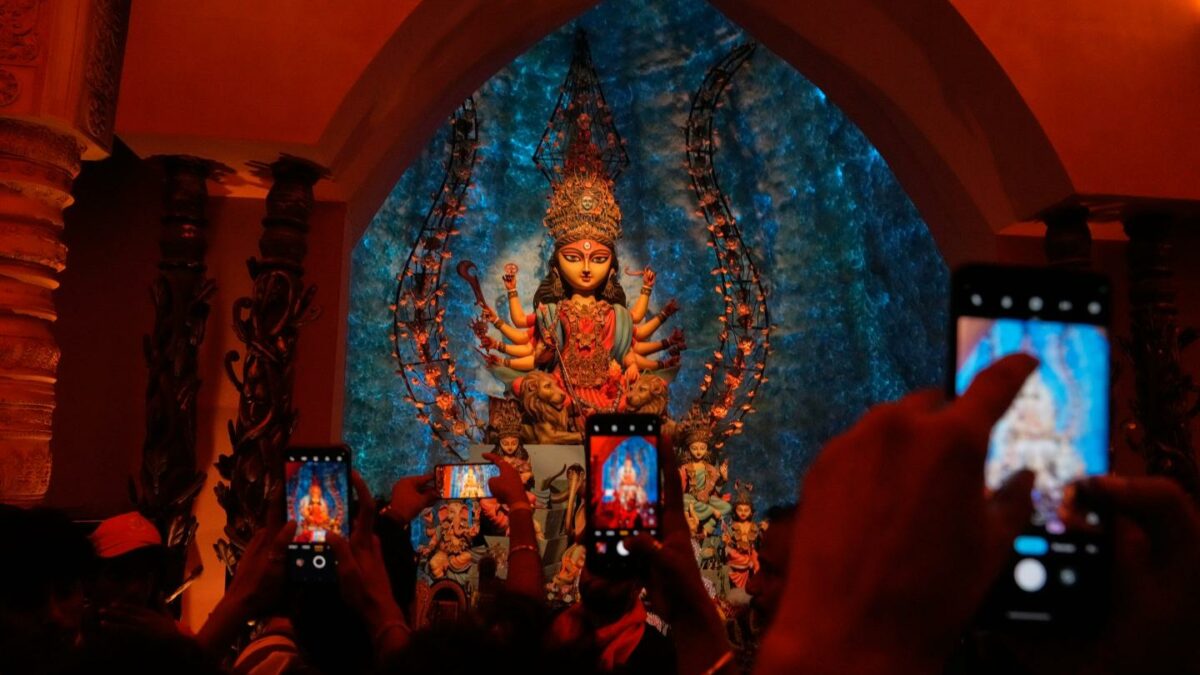 People take photos of an idol of Hindu goddess Durga at a makeshift worship venue on the last day of the festival Durga Puja, in Kolkata, India, Oct. 21, 2026.