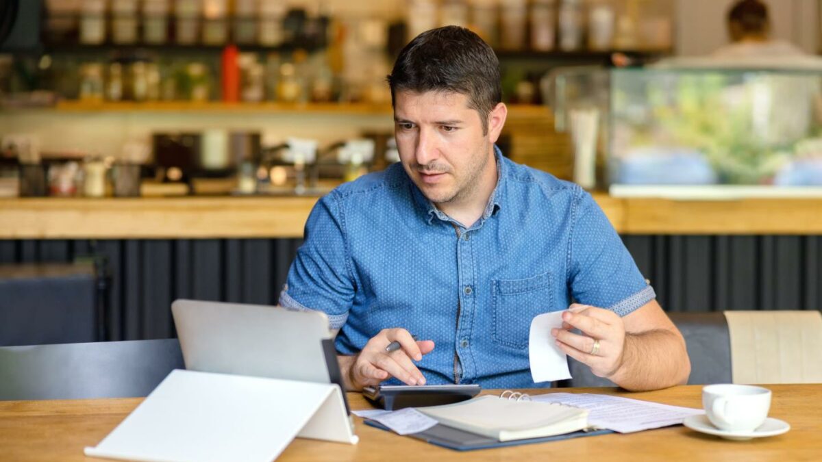 A person at a cafe working on their computer.